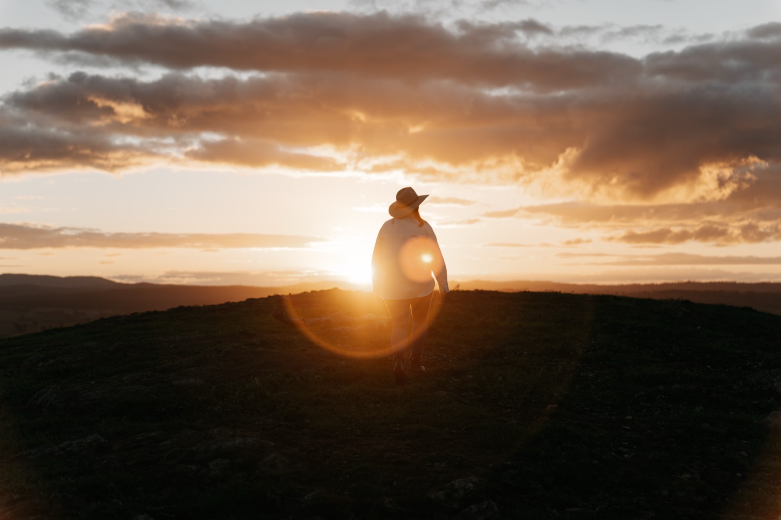 Farmer at sunset on a hilltop